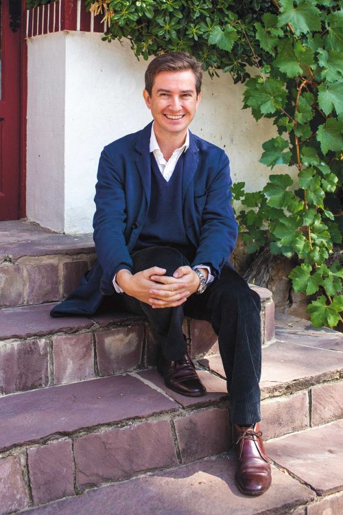 Victor Urrutia - CEO of CVNE dressed in a casual blue jacket, sits on the winery steps in Haro, Rioja