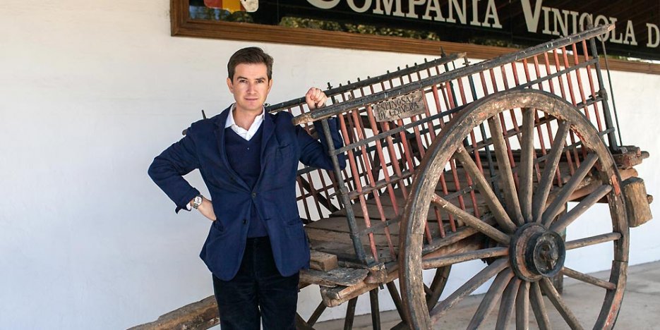 Victor Urrutia - CEO of CVNE dressed in a casual blue jacket leaning against old wooden cart