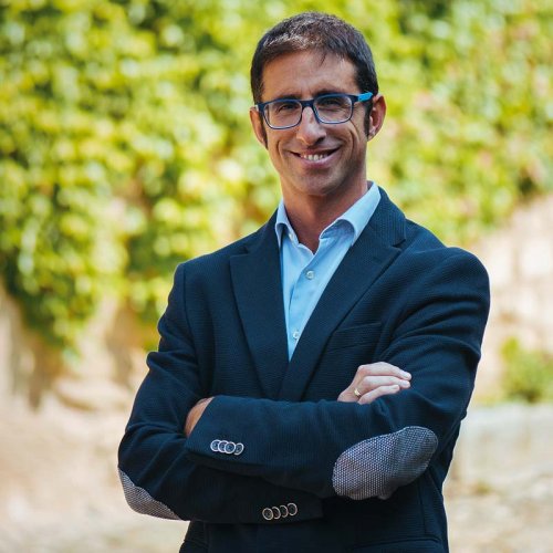 Jorge Navascués - Head Winemaker of Contino, wearing a smart dark blue blazer, and fashionable blue glasses, stood outside the winery