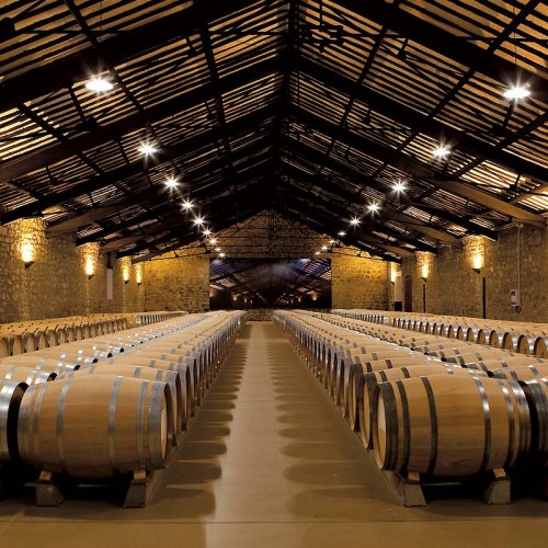 Cune barrel hall in Haro, Rioja. The black wooden beams of the arched roof that protect the rows of barrels below