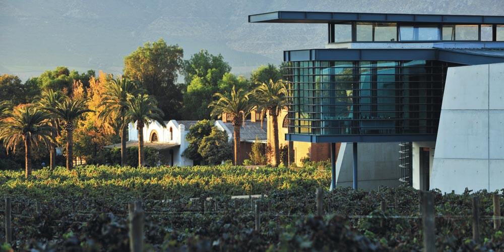Original Errazuriz casa winery in the background with the new icon winery in the foreground, surrounded by vines