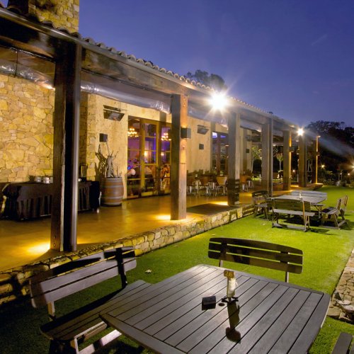 Robert Oatley's Margaret River Cellar Door visitor centre, outdoor veranda and grassed area floodlit in the evening