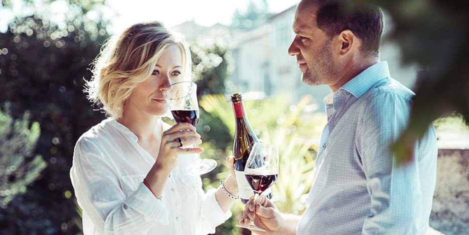 Grégory and Virginie Barbet enjoying a bottle of their red wine in the sunshine