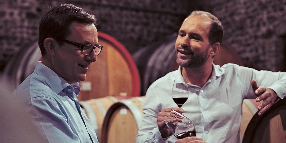 Frédéric Maignet, Consultant Oenologist talking with Grégory Barbet, President, in the cellars while sampling red wines