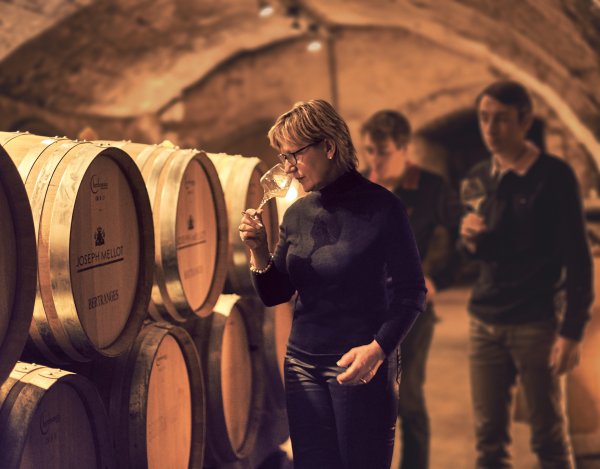 Catherine Corbeau-Mellot checks the aromas of a white wine sample pulled from the cask in the cellar