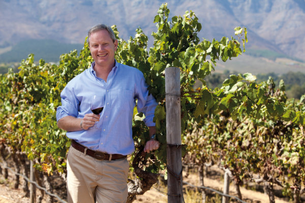 Alastair Rimmer - Cellar Master in the vineyard, wearing a pale blue shirt and cream trousers