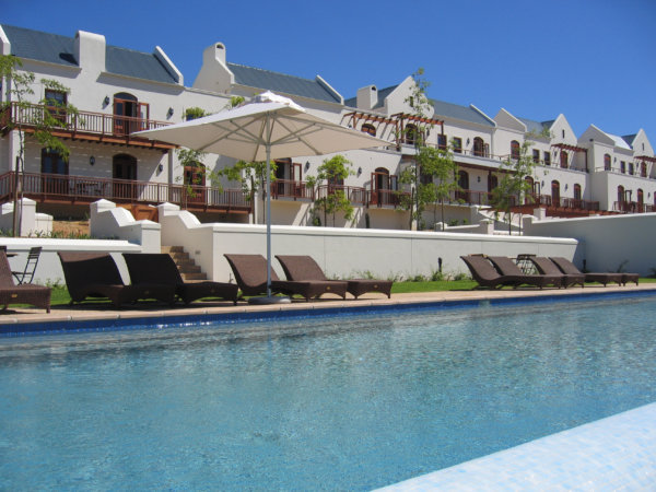 White walls and wooden balconies of the Kleine Zalze lodge and swimming pool