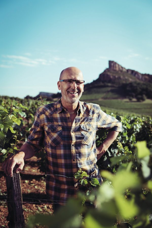 Denis Bouchacourt of Domaine des 3 Tilleuls standing in his Pouilly-Fuissé vineyard with the Roche de Solutré in the backgrounc