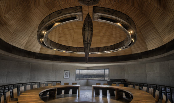 Circular winery tasting room with a tall droplet shaped sculpture hanging from ceiling