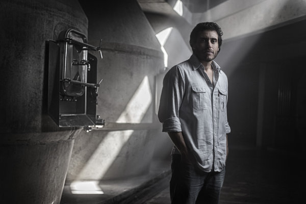 Sebastián Zuccardi standing in front of concrete fermenters in the winery