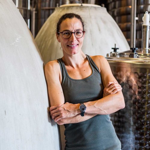 Audrey Braccini - Winemaker and Manager of Domaine Ferret, leaning against a concrete 'egg' fermenter